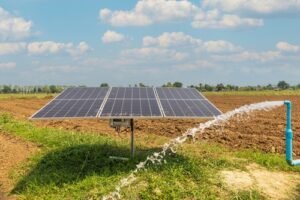 Solar panel powering a water pump irrigating farmland.